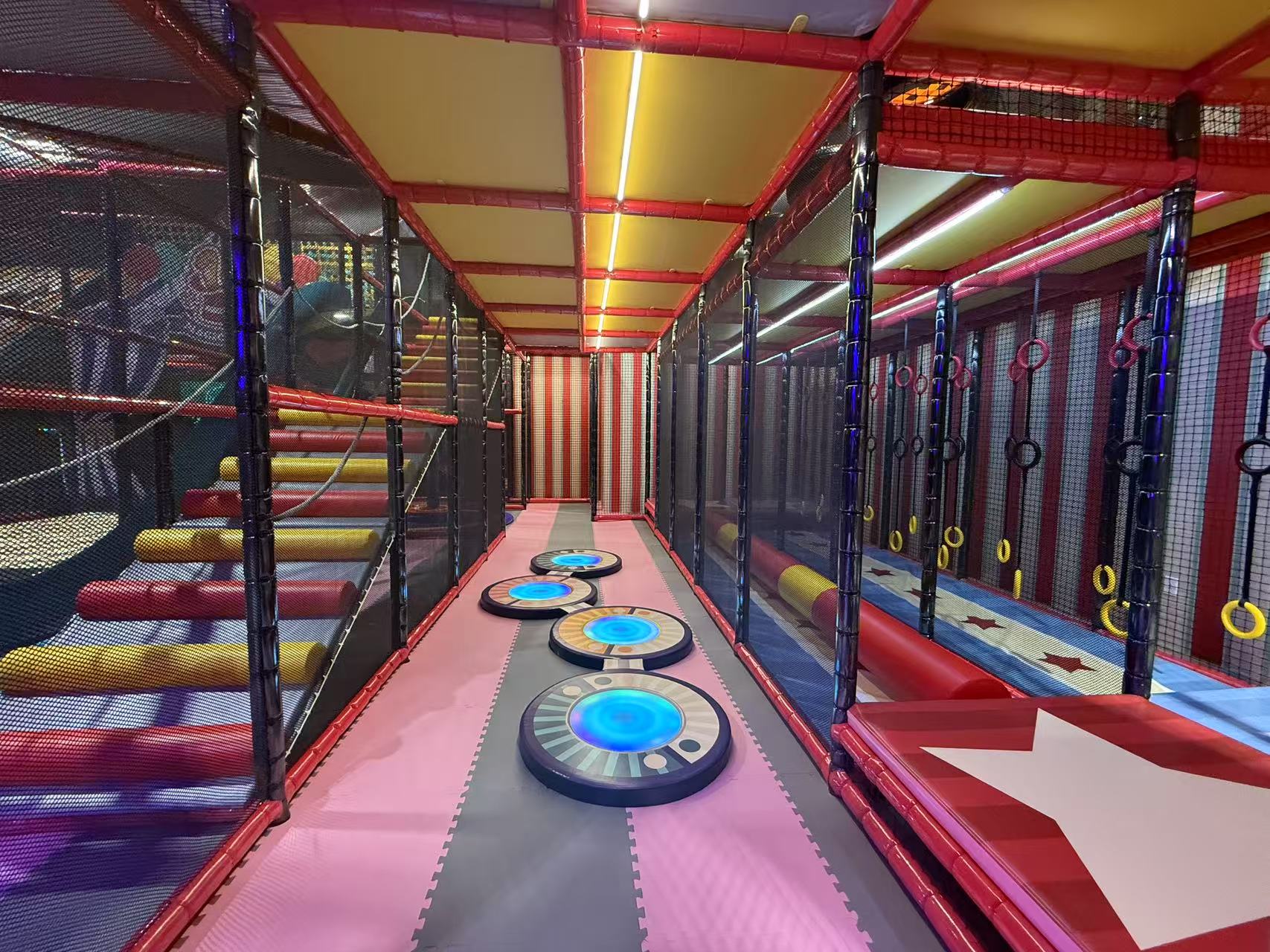 Padded steps, hanging rings and circular stepping pads in Me Land’s netted play structure.