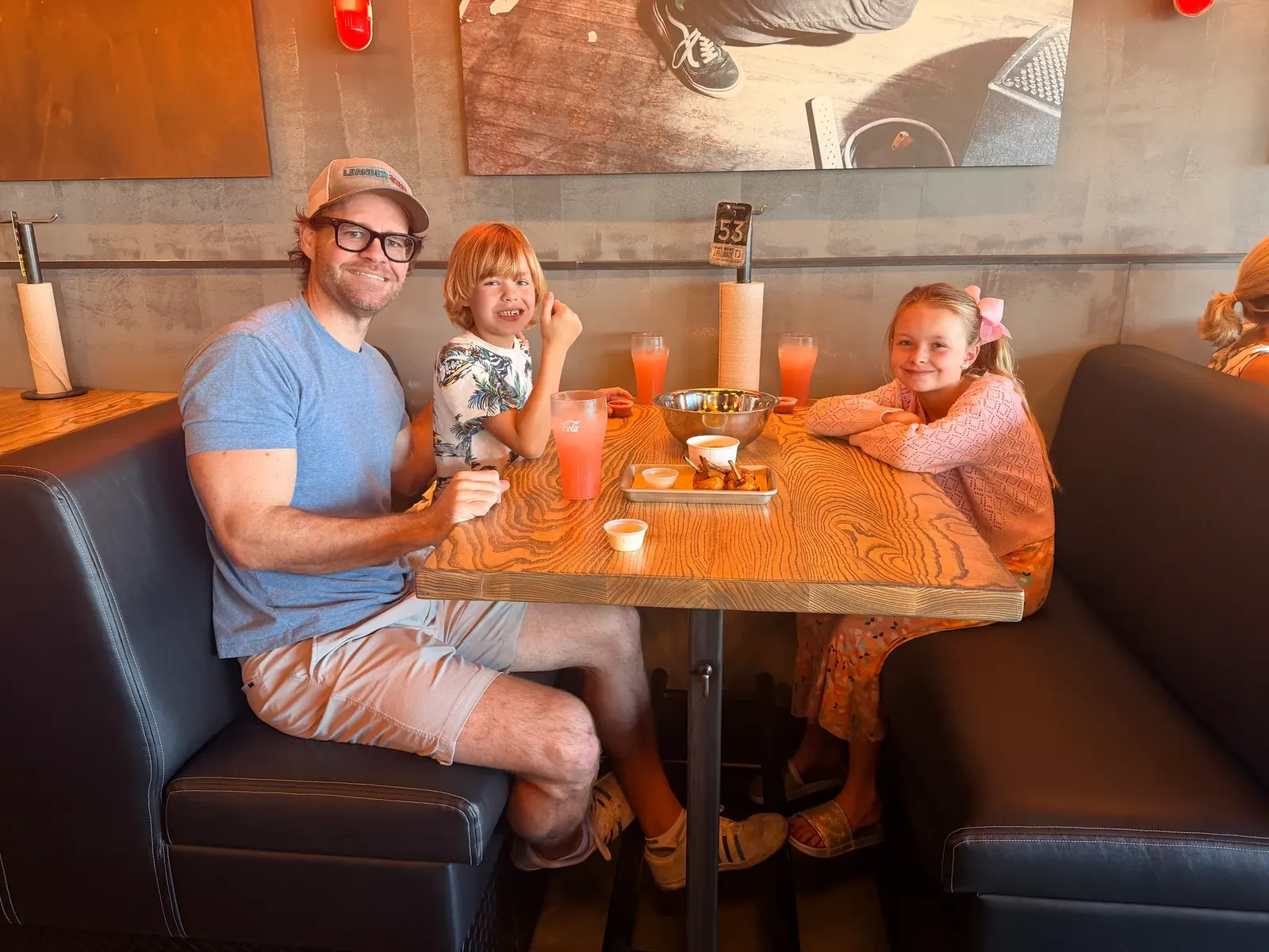 TJ Larkin and his children seated in a booth during the Hopdoddy Leander friends-and-family opening