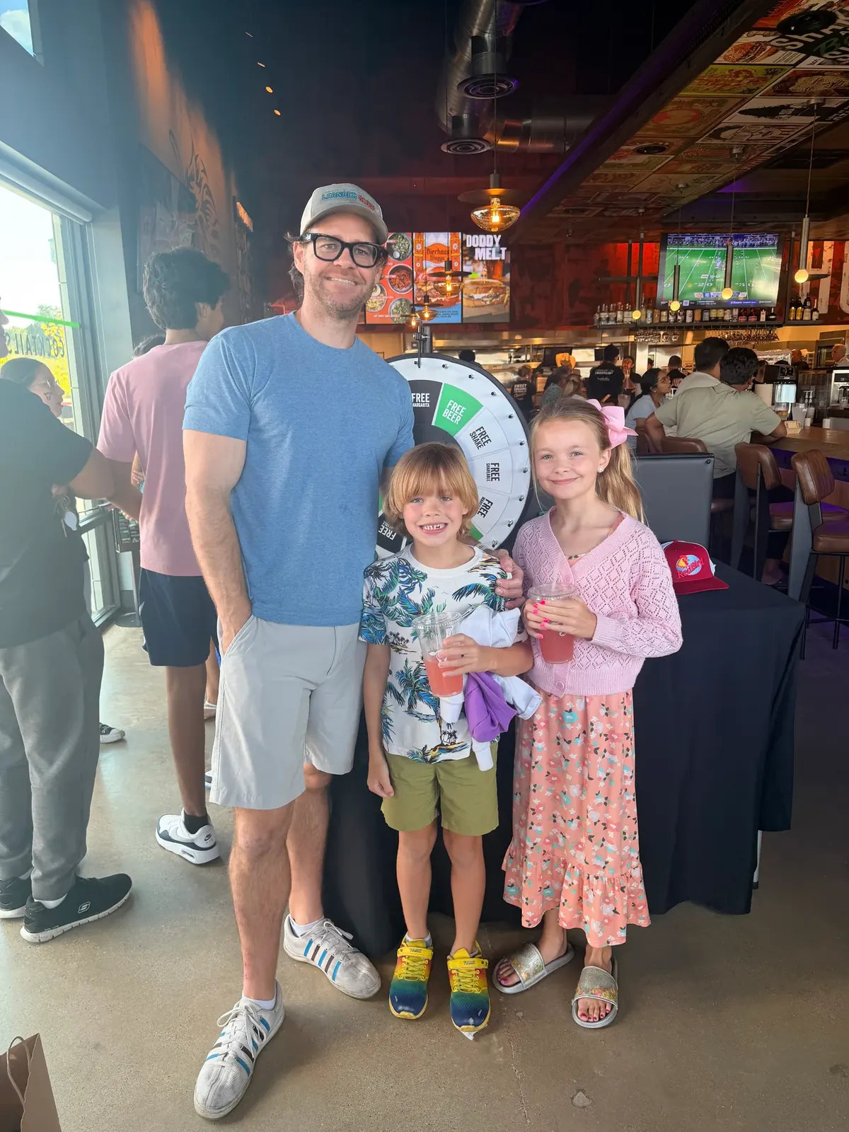 TJ Larkin and his children inside the new Hopdoddy restaurant in Leander
